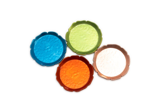 Hammered aluminum texture shows on the four scalloped round coasters in blue, green, orange, and and pink, shown on a plain white background