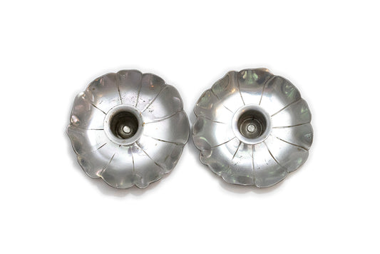 A pair of vintage McClelland Barclay silver color aluminum flower-shaped taper candle holders with scalloped petals, shown from above on a plain white background.