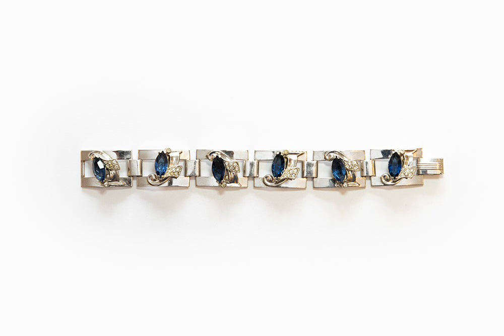 Uncommon rhodium plated silvertone Art Moderne link bracelet has blue navettes and clear rhinestones. Made 1938 - 1940 and signed McClelland Barclay.