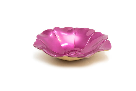 A glossy fuchsia pink flower-shaped dish with a tan colour base, photographed on a clean white background.