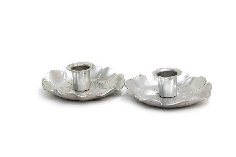 Two vintage McClelland Barclay silver color aluminum metal candle holders with a flower petal design, shown on a plain white background.