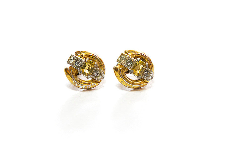 Pair of vintage Art Deco gold plated earrings with yellow and clear rhinestones on a white background