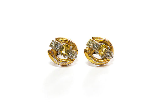 Pair of vintage Art Deco gold plated earrings with yellow and clear rhinestones on a white background