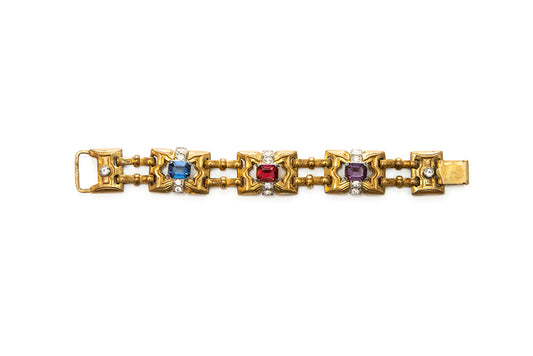 Vintage McClelland Barclay Art Deco gold plated bracelet featuring alternating square links with blue, red, and purple rhinestones, accented by small clear rhinestones, shown on a white background