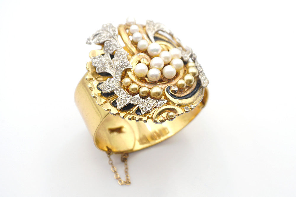 Detail of three dimensional design with rhinestones, faux creamy white and gold pearls, and black enamel work on rare McClelland Barclay cuff bracelet