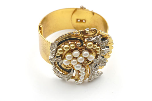 Clear rhinestones, white and gold faux pearls and black enamel work create the central 3-D design of this rare  collectible McClelland Barclay vintage gold-plated cuff bracelet