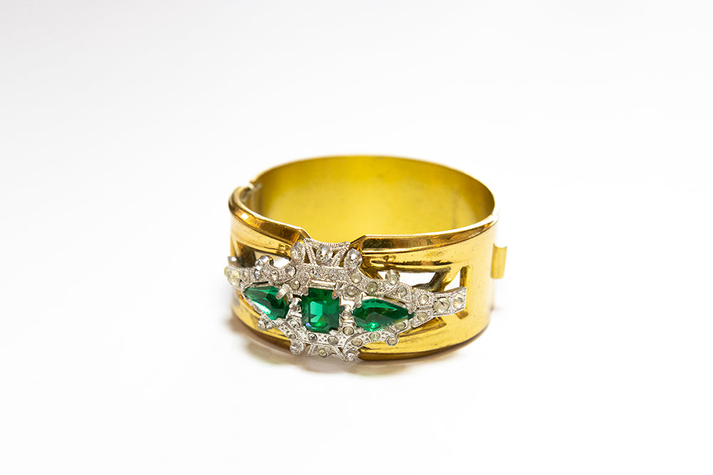 McClelland Barclay Art Deco hinged cuff bracelet with green and clear rhinestones, shows cut-out design.