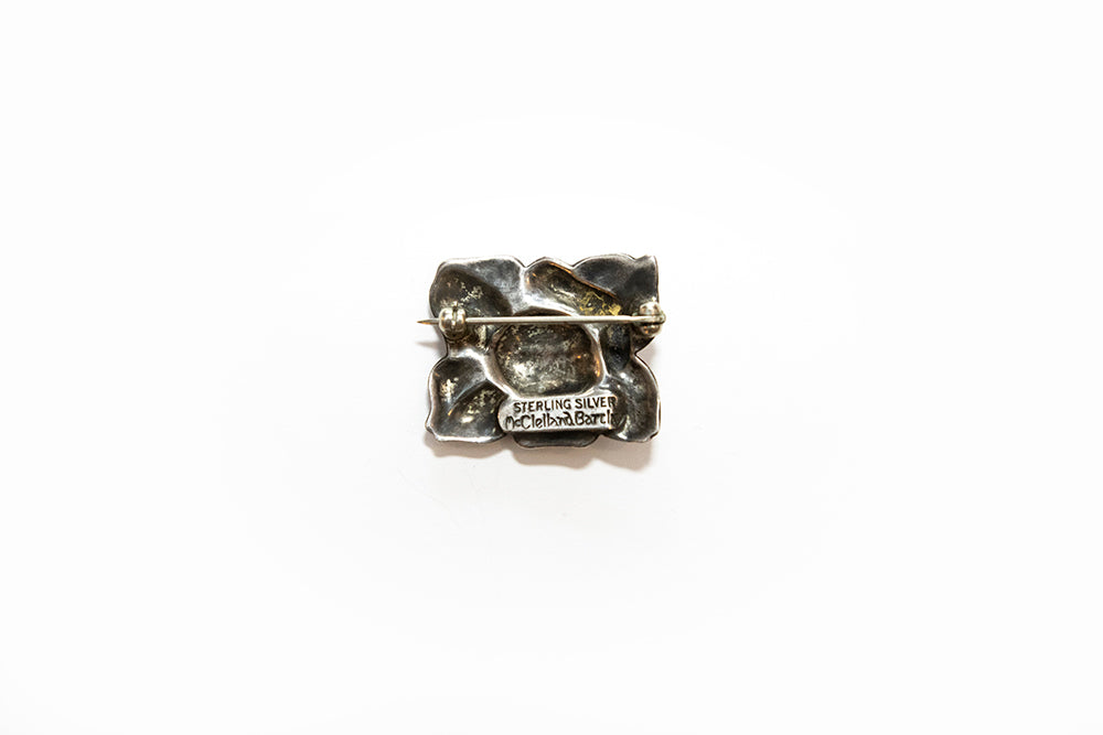 back view of vintage flower brooch stamped "STERLING SILVER McCLELLAND BARCLAY"